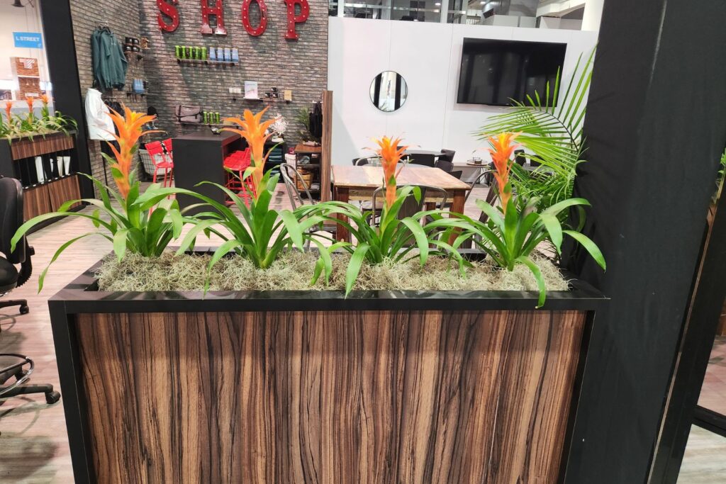 tall brown planter box in a room with colorful plants on top
