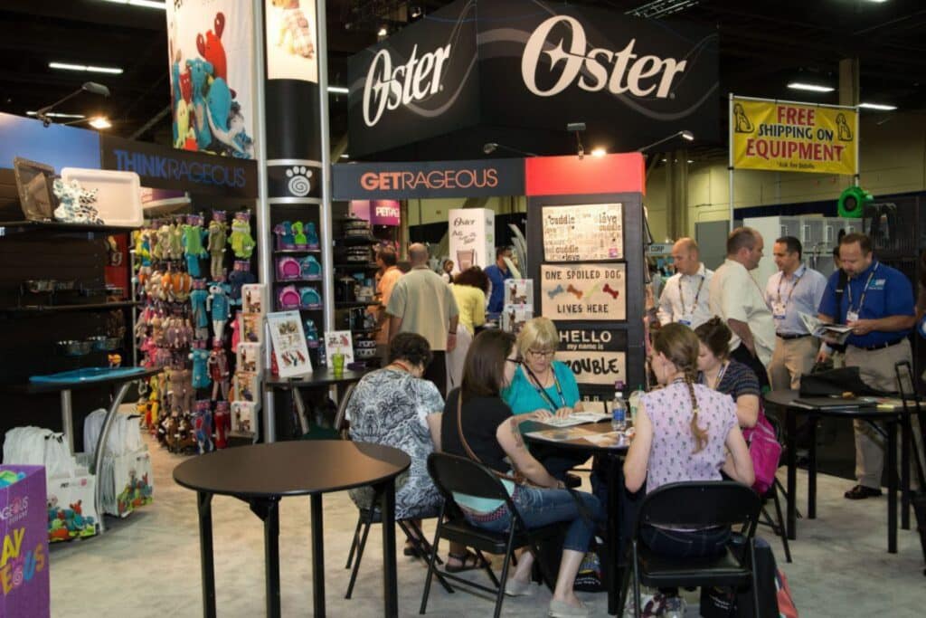 group of people sitting at a table on a trade show floor