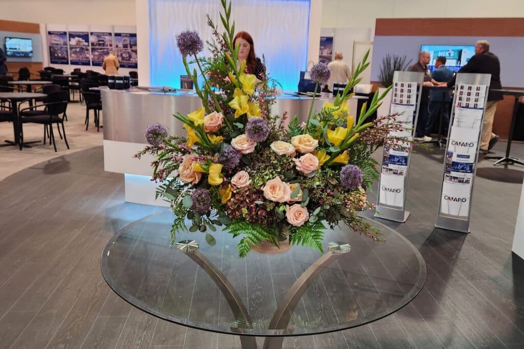 large floral centerpiece on a table in front of a trade show booth